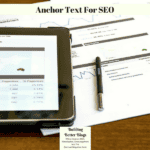 A tablet and some papers along with a pen on a tabletop.