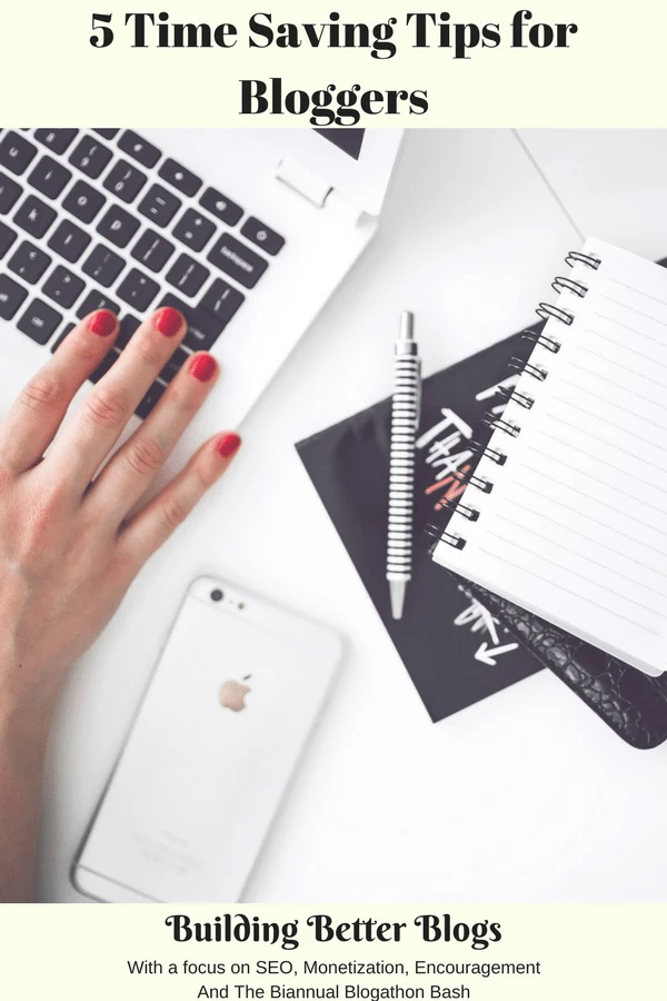 A womans hand on a laptop keyboard with a pen , iPhone and notepads off to the side.